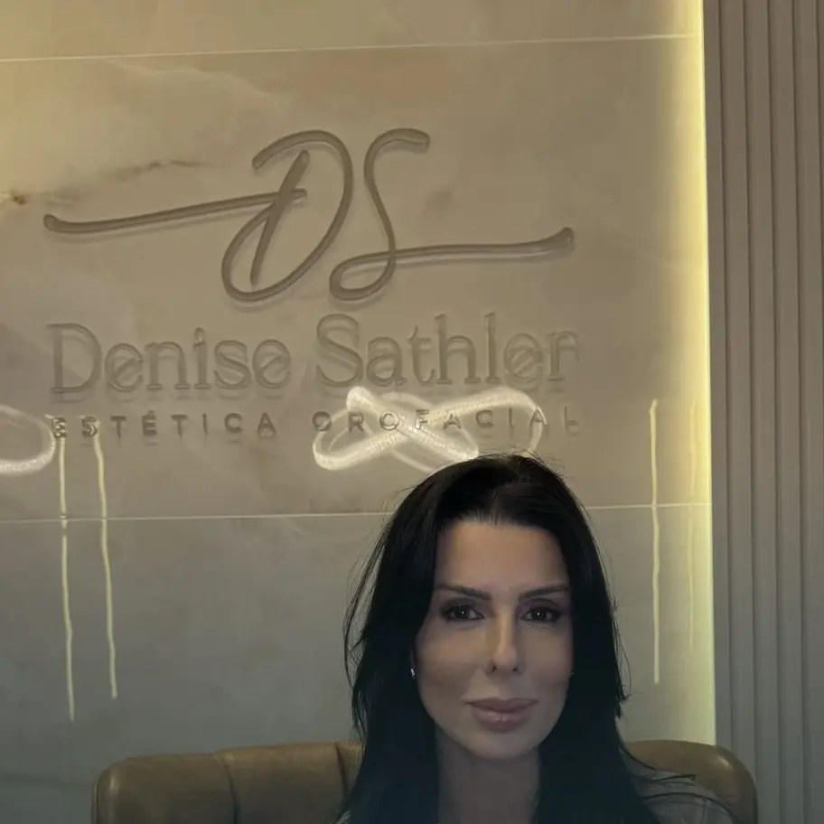 Recepção do consultório Denise Sathler Estética Orofacial, com logo na parede